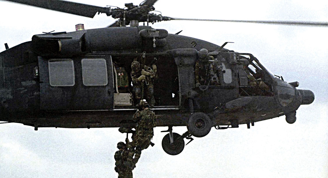Army SOF soldiers fast-roping out of a 160th SOAR MH-60L Black Hawk helicopter.