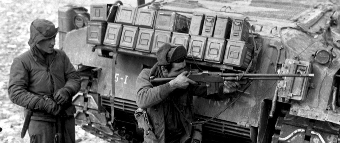 Taking cover behind their tank escort, one man of this ranger patrol of the 5th RCT, U.S. 24th Infantry Division, uses his BAR to return the heavy Chinese Communist small arms and mortar fire which has them pinned down on the bank of the Han River.