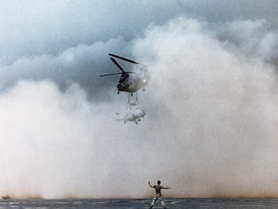 The lead Chinook as it begins to set down the Hind on the N’Djamena airfield. While the dust in the foreground is from the prop wash, the sand storm looms in the background.