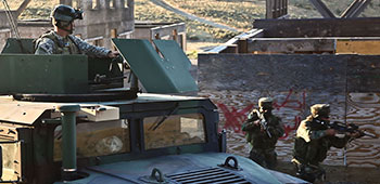 PARA (SF) soldiers move through a mock town under the watch of a 1st SFG soldier during at Yakima Training Center on 11 August 2011.