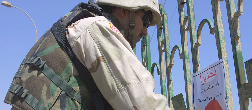 In addition to loudspeaker broadcasts to defuse mob tension, the 315th Tactical Psychological Operations Company produced posters warning looters to stay away from public buildings, such as this one being posted on a gate outside Central Baghdad Railroad Station.