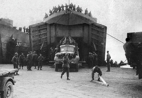 A FSSF Service Battalion 6 x 6 truck unloads from an LST (Landing Ship-Tank) at the Anzio beachhead.