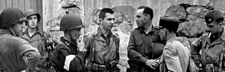 November 1942. Major General Terry de la Mesa Allen, Commander of the 1st Infantry Division, and Lieutenant Colonel Darby confer during a training exercise in North Africa. Also pictured are Rangers Captain Stephen J. Meade and Captain Frederick J. Saam.