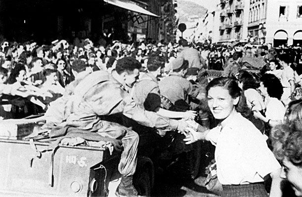 As the 551st entered towns in southern France they often received an enthusiastic welcome. Shown here is Private First Class Richard Field riding in the back of a jeep trailer on 29 August 1944 in Nice.