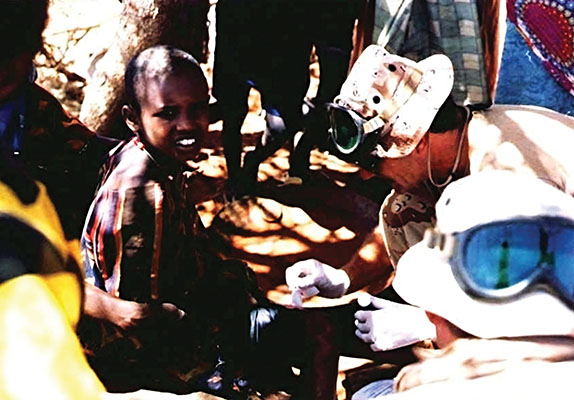 Sergeant First Class Robert Deeks, ODA 562 SF medic, treating boy.