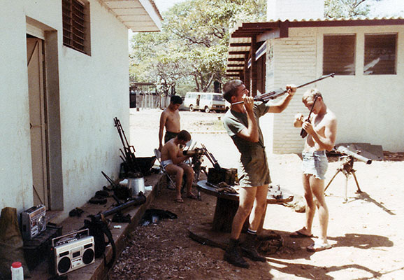 Sergeant First Class LeRoy Sena, Staff Sergeant Davidson, Staff Sergeant Moosey, and SGT David Janicki reconditioning the newly-found Browning Automatic Rifles (BARs) outside their billets in El Bosque.
