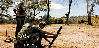 Sergeant First Class LeRoy Sena demonstrates how to “direct lay” a 60mm mortar to the Salvadoran Cazadores.