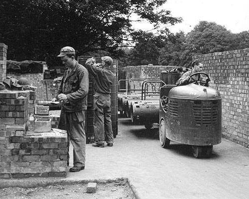 Personnel at the Area H, the SO packing station, prepare aerial delivery containers for loading.