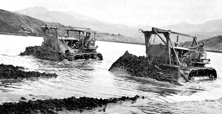 Bulldozers dredging sand from Adak inlet to use as fill for the new airstrip. The ability of the U.S. forces to construct airfields in the Aleutians was a major factor in defeating the Japanese forces on the islands.