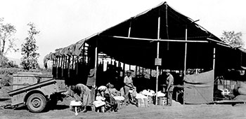 2. Air Drop personel pack supplies outside an improvised warehouse.