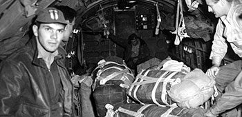 8. Detachment 101 Air Drop personnel wait to kick supplies from a fully loaded C-47 over Burma, 1944.