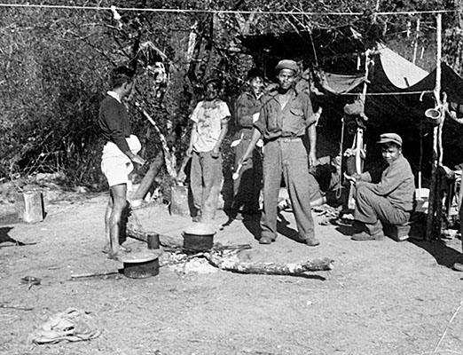 Kachins of OSS Area #1 cook rice over an open fire. Rice—supplemented with what was available—was a staple for American and indigenous soldiers in Detachment 101.