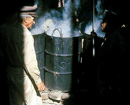 Food for the Rangers, a mixture of rice, corn and some meat, was prepared in 55-gallon drums that served as communal feeding barrels. Observing the preparation is the Battalion S-4, a 1930s Chaco War veteran.