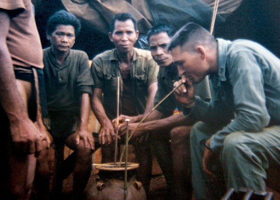 CPT John Schmidt demonstrates communal drinking of rice wine.