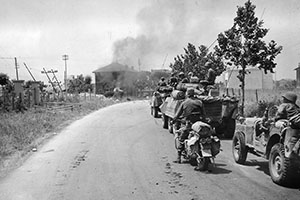 Task Force Ellis (91st Reconnaissance Squadron), a competitor to Task Force Howze, drives into the outskirts of Rome on 4 June 1944. In the center of the photo is an M-4 Sherman tank hit by a German 88mm self-propelled gun. 