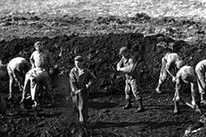 In order to pitch their Bell tents in the tundra, the Forcemen rolled back the muskeg and dug down to the volcanic bedrock. They drove their tent pegs into the rock to hold the tents up in the nearly continuous heavy winds.