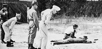 MAJ John D. Striegel, COL Aaron Bank, CPT Dorsey B. Anderson, and COL Charles H. Karlstad observe 10th SFG pistol marksmanship at Fort Bragg, North Carolina, 1952.