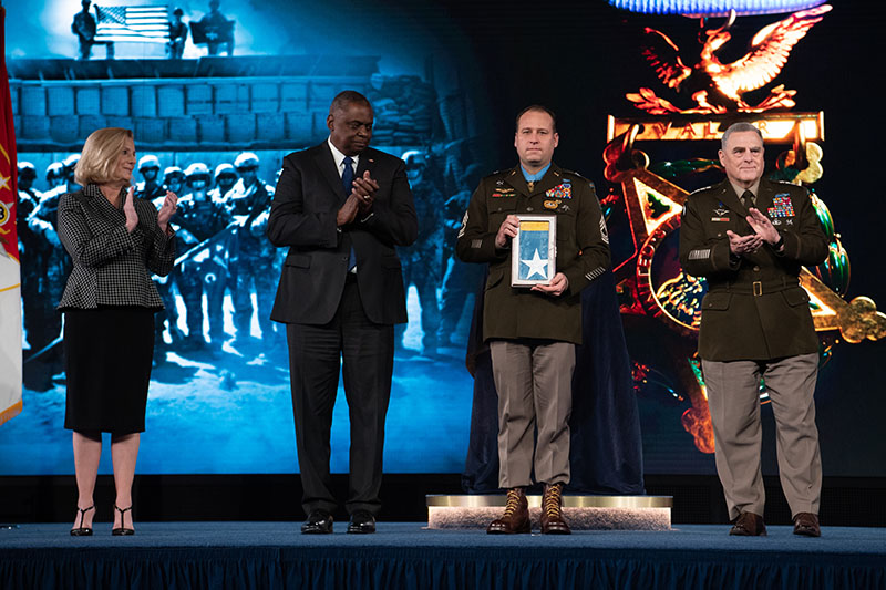 Secretary of the U.S. Army Christine E. Wormuth, Secretary of Defense Lloyd J. Austin III and Chairman of the Joint Chiefs of Staff U.S. Army Gen. Mark A. Milley present the Medal of Honor flag to U.S. Army Master Sgt. Earl D. Plumlee during a Medal of Honor Induction Ceremony at Joint Base Myer-Henderson Hall, Va., Dec. 17, 2021. Master Sgt. Plumlee was awarded the Medal of Honor for actions of valor during Operation Enduring Freedom while serving as a weapon’s sergeant with Charlie Company, 4th Battalion, 1st Special Forces Group (Airborne), near Ghazni, Afghanistan, Aug. 28, 2013.