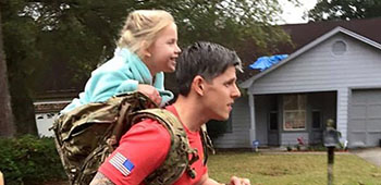 Sgt. 1st Class Christopher Celiz performs physical training carrying his daughter on his back. On this day, they completed over a mile together.